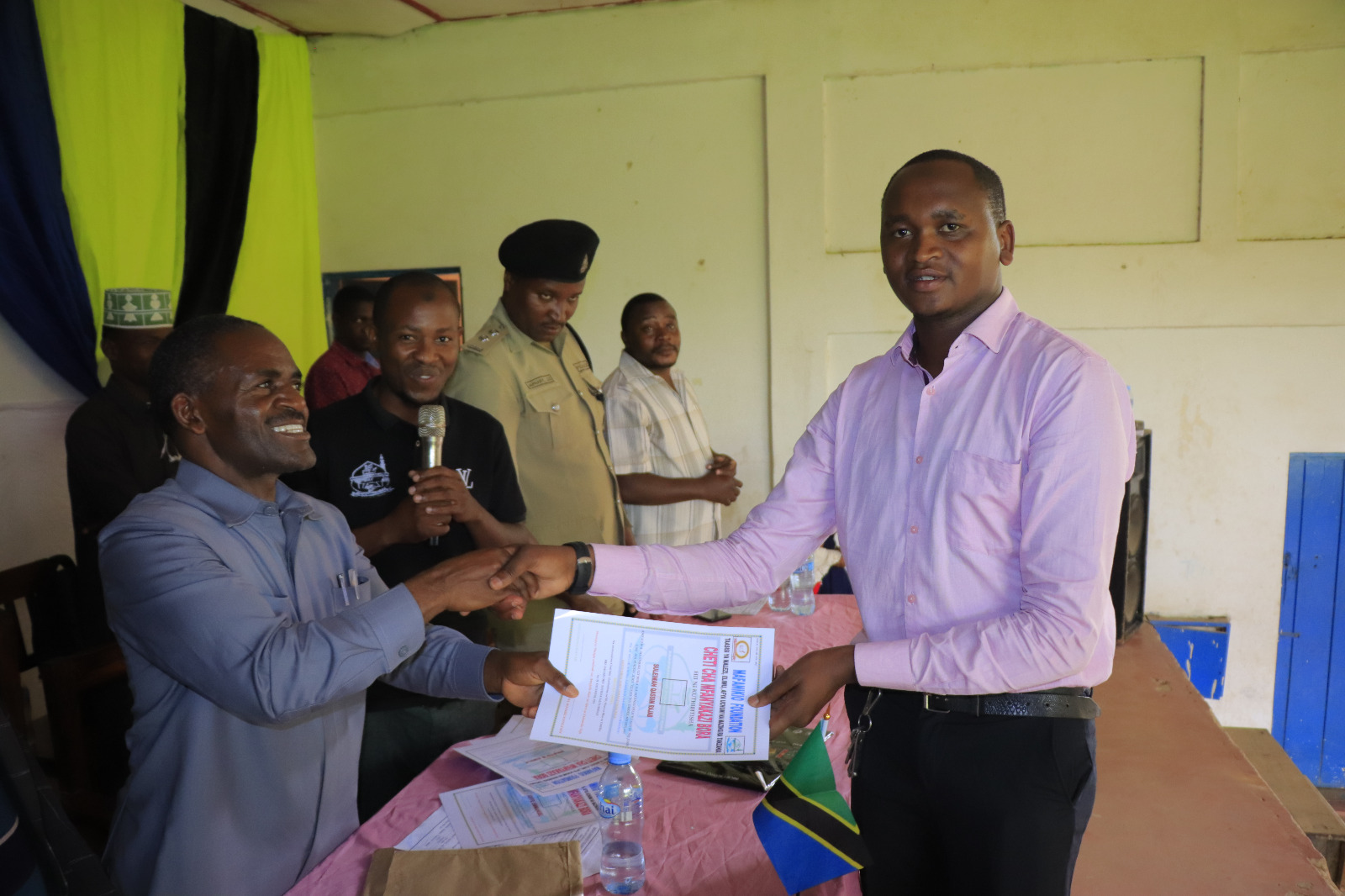 Photos of Mafanikio Foundation volunteers receiving certificates of honor from the Regional Education Officer of Tabora, Mr. Juma Japhet Kaponda, on behalf of the Regional Commissioner of Tabora, for successfully ensuring that all primary school graduates receive special training. Additionally, they launched the campaign "No Child Left Behind - Quality Education for All